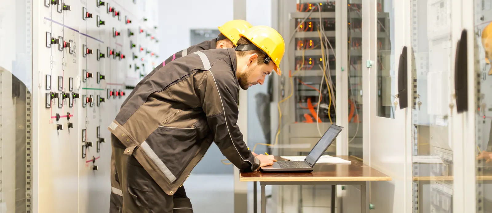 Ingeniero realizando una auditoría energética con laptop frente a un tablero eléctrico