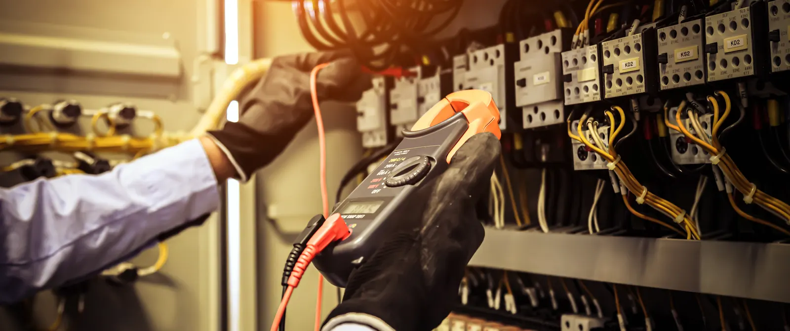 Técnico midiendo con pinza amperimétrica en un tablero eléctrico